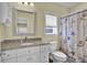 Bright bathroom with granite countertop, white cabinets, decorative shell-themed shower curtain, and neutral wall color at 421 30Th Ave. S, Sunset Beach, NC 28468