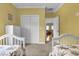 Bright bedroom featuring twin beds with floral bedding and an open doorway leading to a connected living area at 421 30Th Ave. S, Sunset Beach, NC 28468