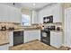 Updated kitchen with granite countertops, white cabinets, and black appliances at 421 30Th Ave. S, Sunset Beach, NC 28468