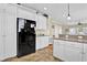 Well-lit kitchen featuring white cabinets, granite countertops, and a modern, black refrigerator appliance at 421 30Th Ave. S, Sunset Beach, NC 28468