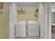 Bright laundry room with washer, dryer, shelving, and a beige paint color on the walls at 421 30Th Ave. S, Sunset Beach, NC 28468