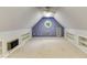 Bright attic featuring a round window, sloped ceilings, white trim, built-in shelves, and ceiling fan at 469 White Heron Ct. Sw, Sunset Beach, NC 28468