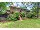 Backyard featuring a two-story home with a deck, stairs to the yard, and lush greenery at 469 White Heron Ct. Sw, Sunset Beach, NC 28468