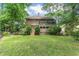 Backyard featuring a two-story home with a deck, steps down to the yard, and mature trees at 469 White Heron Ct. Sw, Sunset Beach, NC 28468