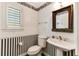 Charming half bathroom featuring pedestal sink, window with blinds, and decorative wallpaper at 469 White Heron Ct. Sw, Sunset Beach, NC 28468