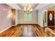 Dining room featuring a chandelier, trim work, hardwood floors, and large window at 469 White Heron Ct. Sw, Sunset Beach, NC 28468