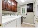 Well-equipped laundry room with storage cabinets, utility sink, and washer/dryer at 469 White Heron Ct. Sw, Sunset Beach, NC 28468