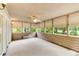 Screened porch with wood paneled walls, multiple windows, roller blinds, and ceiling fan at 469 White Heron Ct. Sw, Sunset Beach, NC 28468
