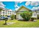 Exterior building with a grill and parking nearby with mature landscaping at 5050 Windsor Green Way # 203, Myrtle Beach, SC 29579