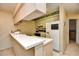 Cozy kitchen with white appliances, breakfast bar, and overhead cabinets at 5050 Windsor Green Way # 203, Myrtle Beach, SC 29579