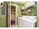 The practical laundry area includes a washer, dryer, and shelving for optimal organization at 5050 Windsor Green Way # 203, Myrtle Beach, SC 29579