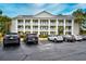 A view of the building exterior with well-maintained landscaping and a spacious parking lot at 5050 Windsor Green Way # 203, Myrtle Beach, SC 29579