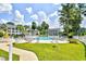 A refreshing community pool surrounded by lush landscaping and comfortable lounge chairs at 5050 Windsor Green Way # 203, Myrtle Beach, SC 29579