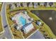Aerial view of the community pool, featuring lounge chairs, a clubhouse, and a serene pond at 520 Cattle Drive Circle, Myrtle Beach, SC 29588
