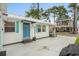Side view of a cozy beach house featuring a painted door, windows with shutters, and a well-maintained yard at 6001-1680 S Kings Hwy., Myrtle Beach, SC 29575