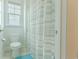 Cozy bathroom with a toilet, striped shower curtain, and window providing soft, natural light at 6186 Chadderton Circle, Myrtle Beach, SC 29579