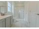 Bright bathroom features a glass-enclosed shower, grey vanity, and tiled flooring for a clean, modern look at 6186 Chadderton Circle, Myrtle Beach, SC 29579