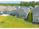 Aerial view of the home's backyard with a patio, grill, and lush lawn in a neighborhood setting at 6304 Chadderton Circle, Myrtle Beach, SC 29579