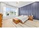 Stylish bedroom with a modern blue accent wall, hardwood floors, and plenty of natural light at 6304 Chadderton Circle, Myrtle Beach, SC 29579