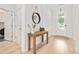 Bright entryway featuring hardwood floors, a wooden console table, and a front door allowing ample natural light at 6304 Chadderton Circle, Myrtle Beach, SC 29579