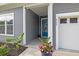 Charming front porch with blue door, lovely plants, and garage access at 6304 Chadderton Circle, Myrtle Beach, SC 29579