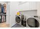 Bright laundry room with modern washer and dryer, built in cabinets, and an adjacent walk-in closet at 6304 Chadderton Circle, Myrtle Beach, SC 29579