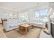 Bright and airy living room featuring comfortable seating, a wooden coffee table, fireplace, and large windows at 6304 Chadderton Circle, Myrtle Beach, SC 29579