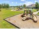 Community playground featuring slides and play equipment on a well-maintained lawn with mature trees at 6304 Chadderton Circle, Myrtle Beach, SC 29579