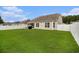 Large backyard with a well-maintained lawn, screened porch, and a white privacy fence at 632 Lafayette Park Dr., Little River, SC 29566