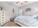A well-lit bedroom showcasing a bed with a grey and white patterned duvet, wood dresser, and soft carpet at 632 Lafayette Park Dr., Little River, SC 29566