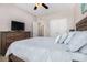 Spacious bedroom with a large bed, wooden dresser with TV, and multiple windows allowing ample light at 632 Lafayette Park Dr., Little River, SC 29566
