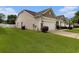Side view of home highlighting the two car garage, lawn, and neutral vinyl siding at 632 Lafayette Park Dr., Little River, SC 29566