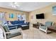 Inviting living room with comfortable blue couch, tile floors, and ceiling fan at 704 S Ocean Blvd. # 304A, Myrtle Beach, SC 29577