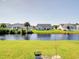 Scenic backyard featuring a calm pond surrounded by green lawns and residential homes at 708 Shenanigan Loop, Murrells Inlet, SC 29576