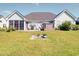 Spacious backyard with a hot tub, screened-in porch, and patio area, perfect for outdoor living at 708 Shenanigan Loop, Murrells Inlet, SC 29576