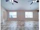 Bright living room featuring two large windows, ceiling fans, and neutral walls at 708 Shenanigan Loop, Murrells Inlet, SC 29576