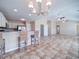 Open-concept living area showcases a modern chandelier, kitchen bar, and stainless steel appliances at 708 Shenanigan Loop, Murrells Inlet, SC 29576