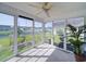 Bright sunroom with large windows offering views of the backyard, complemented by a ceiling fan at 708 Shenanigan Loop, Murrells Inlet, SC 29576
