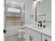 Bathroom with white cabinets, marble countertops, and tiled shower with black and gold fixtures at 729 Jade Dr., Myrtle Beach, SC 29579
