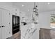 Modern kitchen with white cabinets, gold hardware, black appliances, and a large island with a white marble countertop at 729 Jade Dr., Myrtle Beach, SC 29579