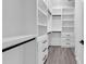 Spacious walk-in closet with custom shelving, drawers, and wood flooring provides ample storage at 729 Jade Dr., Myrtle Beach, SC 29579