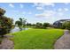 Expansive backyard featuring lush green lawn, a serene lake with a fountain, and mature landscaping at 7961 San Marcello Dr., Myrtle Beach, SC 29579