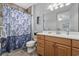Bathroom with blue-patterned shower curtain, white vanity, and decor at 7961 San Marcello Dr., Myrtle Beach, SC 29579