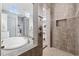 Main bathroom features a tub, walk-in shower with stone accents, and neutral paint at 7961 San Marcello Dr., Myrtle Beach, SC 29579