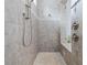 Walk-in shower boasts neutral tile, rainfall shower head, and seamless glass door at 7961 San Marcello Dr., Myrtle Beach, SC 29579