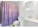Clean bathroom showcasing a toilet, vanity, mirror, and a shower with a purple curtain at 801 Burcale Rd. # K7, Myrtle Beach, SC 29579