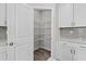 Walk-in pantry featuring white shelving, cabinets, and backsplash at 8249 Vibrant Loop, Longs, SC 29568
