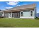 Back of home features a screened in porch and a grassy backyard at 865 Summer Starling Pl., Myrtle Beach, SC 29577