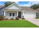 Charming single-story home featuring a quaint front porch, well-manicured lawn, and attached two car garage at 865 Summer Starling Pl., Myrtle Beach, SC 29577