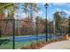 Outdoor pickleball court, features a fenced court with a smooth playing surface surrounded by lush landscaping and ample space at 865 Summer Starling Pl., Myrtle Beach, SC 29577
